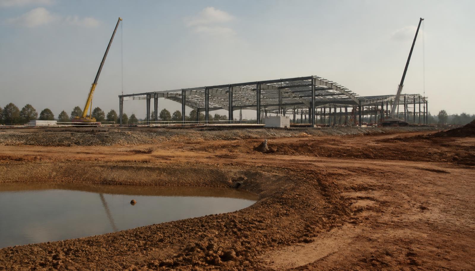 A large data centre under construction, steel frame and cranes on a graded site